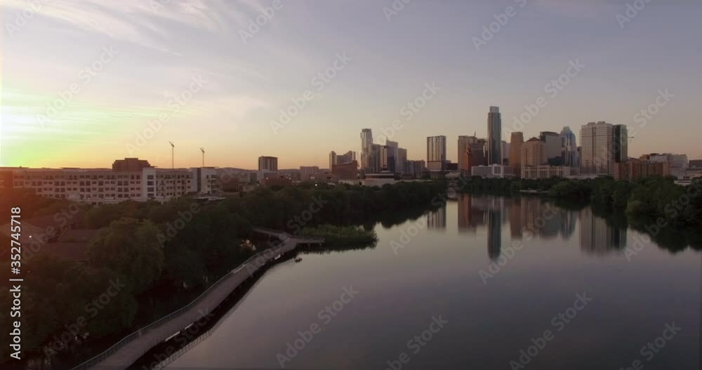 The morning Austin skyline over a calm Lady Bird Lake and empty Hike and Bike Trail boardwalk during the covid coronavirus pandemic The morning Austin skyline over a calm Lady Bird Lake and empty Hike and Bike Trail boardwalk during the covid coronavirus pandemic