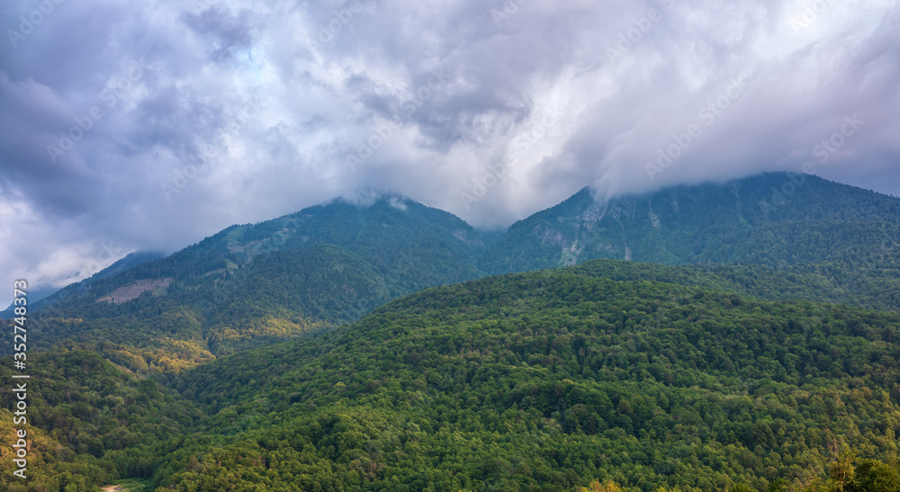 High mountain with rocky slopes hidden in clouds and fog. - obrazy, fototapety, plakaty 