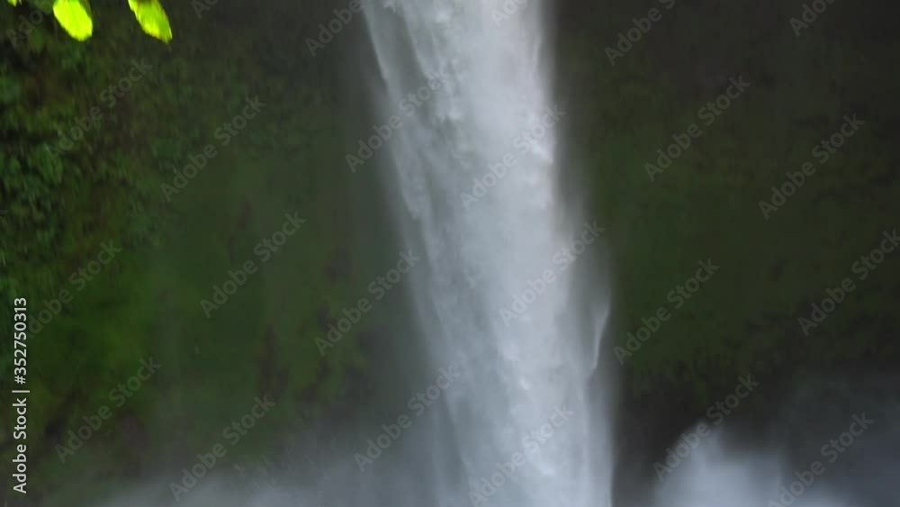 Tropical Waterfall, Tilt Down Slowmotion. Water Flowing in Jungle of Costa Rica Tropical Waterfall, Tilt Down Slowmotion. Water Flowing in Jungle of Costa Rica