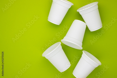 biodegradable beverage containers on a green background, space for text. environmental protection. caring for nature. the rejection of the plastic