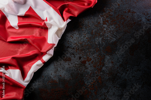 National flag of Canada on dark stone background, beautiful colored with cloth texture and copy space.