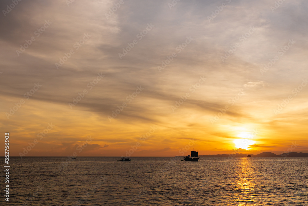Beautiful sunset at the sea. Andaman Sea. Silhouettes of ships on the surface of the water. Thailand. Holidays at sea.