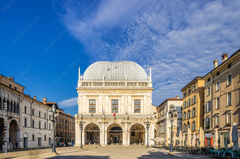 Palazzo della Loggia palace Town Hall Renaissance style building and street lights in Piazza della Loggia Square, Brescia city historical centre, blue sky background, Lombardy, Northern Italy