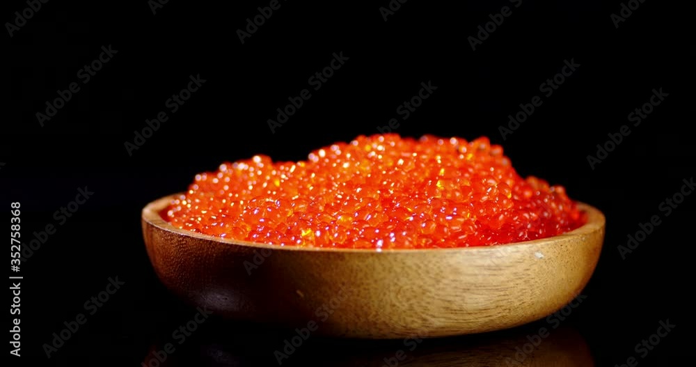 Wooden plate with red caviar rotates slowly. Wooden plate with red caviar rotates slowly.