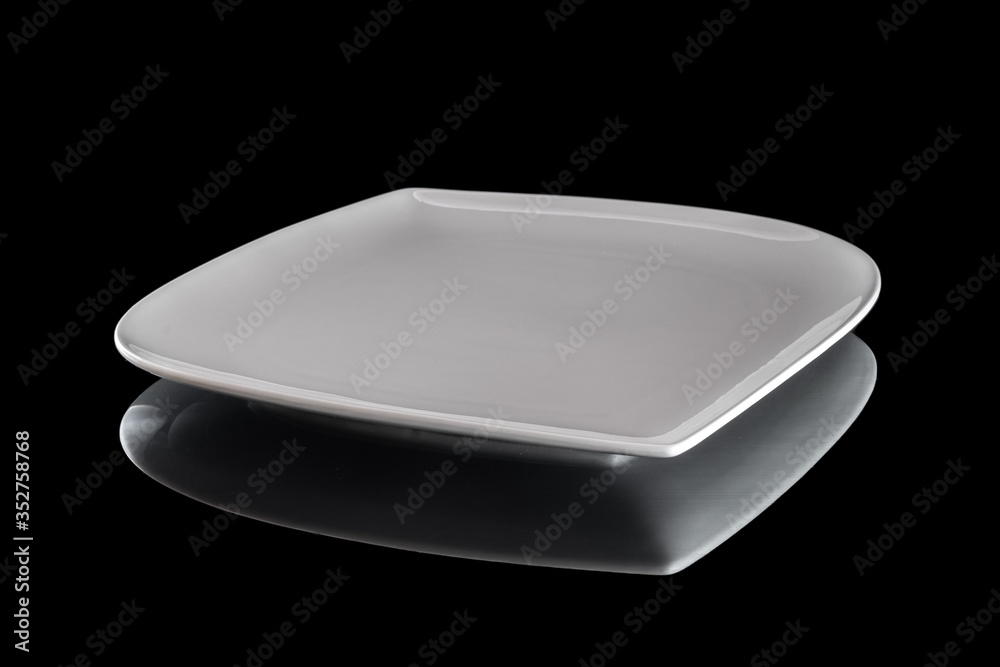 Dishes isolated on black. Square white empty plate for dinner on dark background. Clean circle porcelain crockery. Breakfast tableware. Dishes isolated on black. Square white empty plate for dinner on dark background. Clean circle porcelain crockery. Breakfast tableware.
