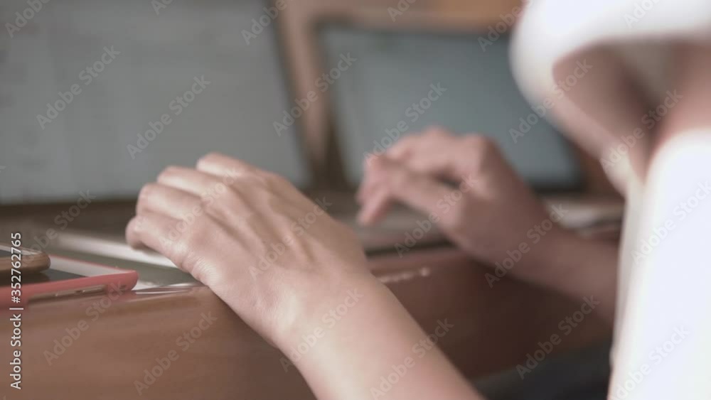 Slow motion video Close up woman hands typing on laptop keyboard. Girl working from home during coronavirus pandemic lockdown. Female work from home on laptop and tablet.