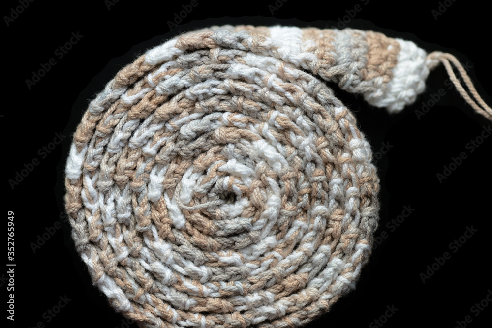 Crochet tape melange yarn rolled up on a black background close up. Top view. Handmade concept Crochet tape melange yarn rolled up on a black background close up. Top view. Handmade concept
