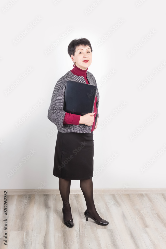 Senior woman holding laptop computer isolated on grey studio background Senior woman holding laptop computer isolated on grey studio background