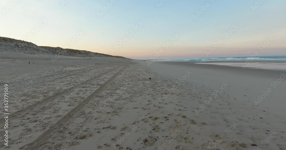 On an empty beach, a forward drone movement close to the ground, water flowing on the right side of the shot On an empty beach, a forward drone movement close to the ground, water flowing on the right side of the shot