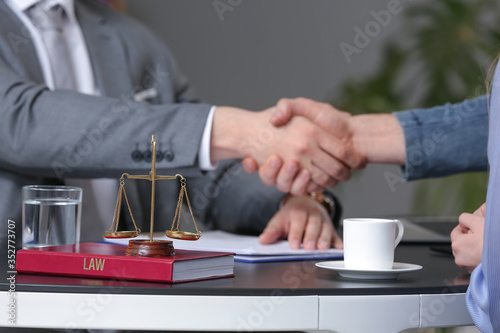 Man and lawyer shaking hands in office
