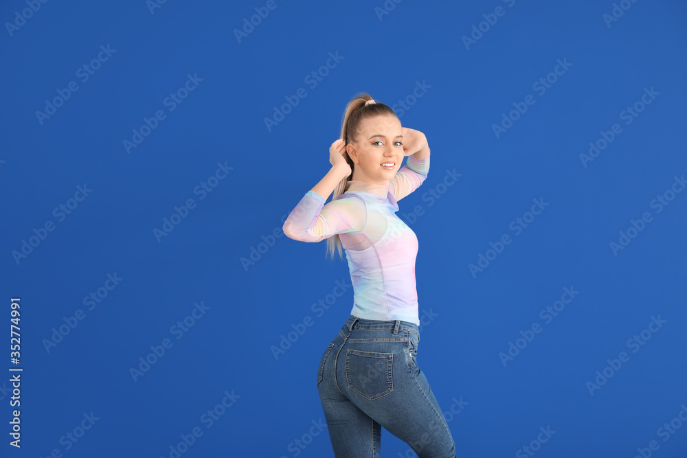 Beautiful young woman dancing against color wall Beautiful young woman dancing against color wall