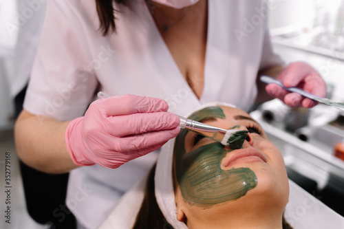 Young woman in a spa with algae facial mask. Woman in spa salon
