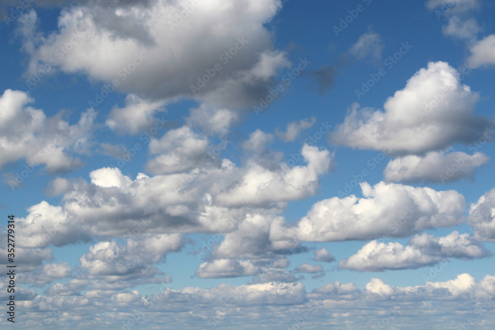 Fototapeta premium White fluffy clouds on a background of blue sky in summer. The concept of weather and climate.