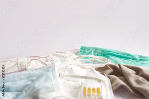 Blurred of used masks on white copy space background. A pile of protection N95 masks and medical surgical masks 