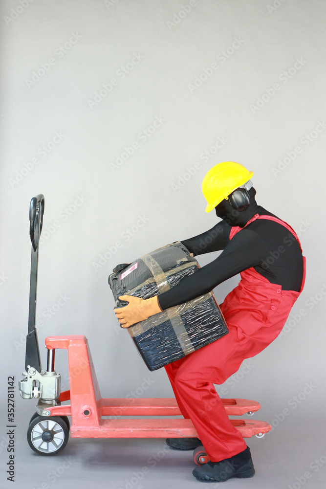 Anonymous worker dealing with heavy package at manual pallet truck.Incorrect body position.Occupational safety and health. Anonymous worker dealing with heavy package at manual pallet truck.Incorrect body position.Occupational safety and health.