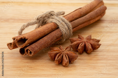 Star anise and cinnamon sticks on wooden background.