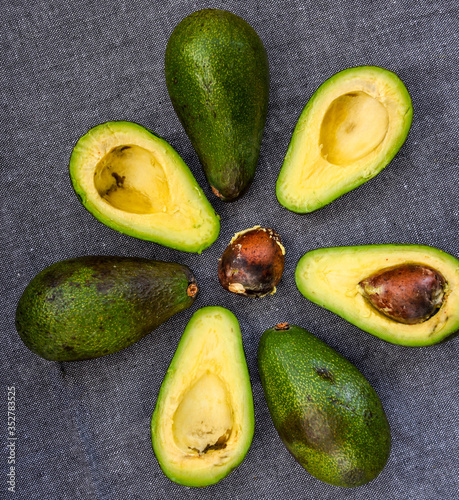 ripe sliced avocado on dark background, top view, photo