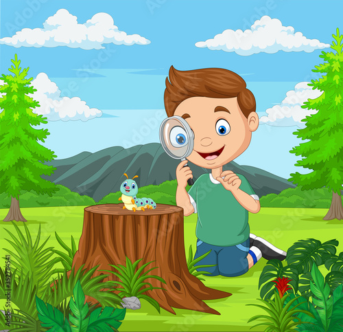 Little boy looking at caterpillar using magnifier in the garden