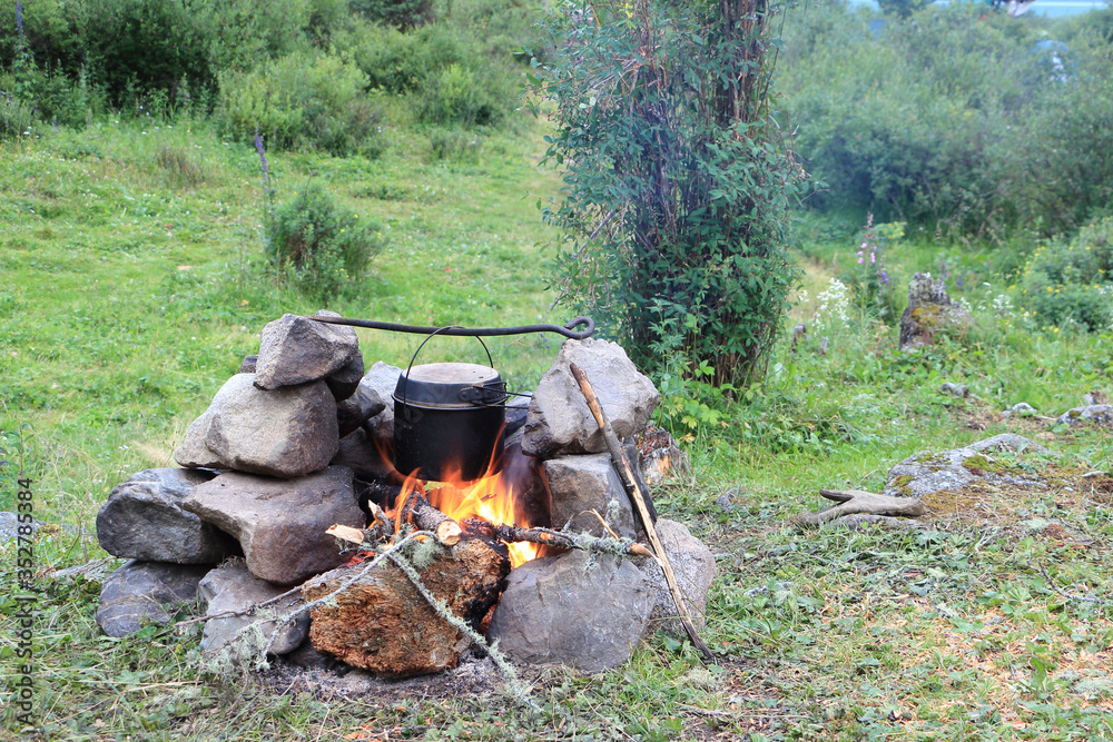 Cooking in a tourist bowler on a bonfire in the stones Cooking in a tourist bowler on a bonfire in the stones