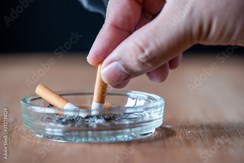 man hand extinguish the cigarette in the ashtray , stop smoking concept photo