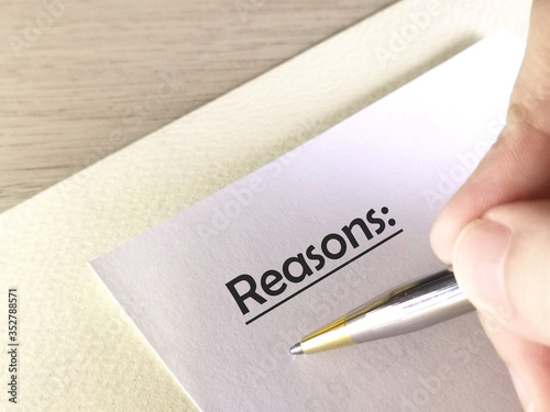 One person is writing on paper about reasons.