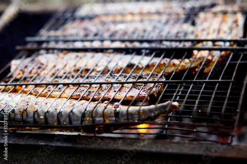 Grilled fish mackerel, cooked on the grill in the open air flow tasty and fresh food, picnic outdoor recreation. Barbeque in the garden in summer at home. photo