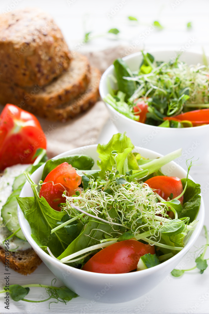 Micro greens salad with tomatoes, cucumber, leaves mix salad .Healthy food background. Vegan food, diet food, healthy eating concept. Micro greens salad with tomatoes, cucumber, leaves mix salad .Healthy food background. Vegan food, diet food, healthy eating concept.