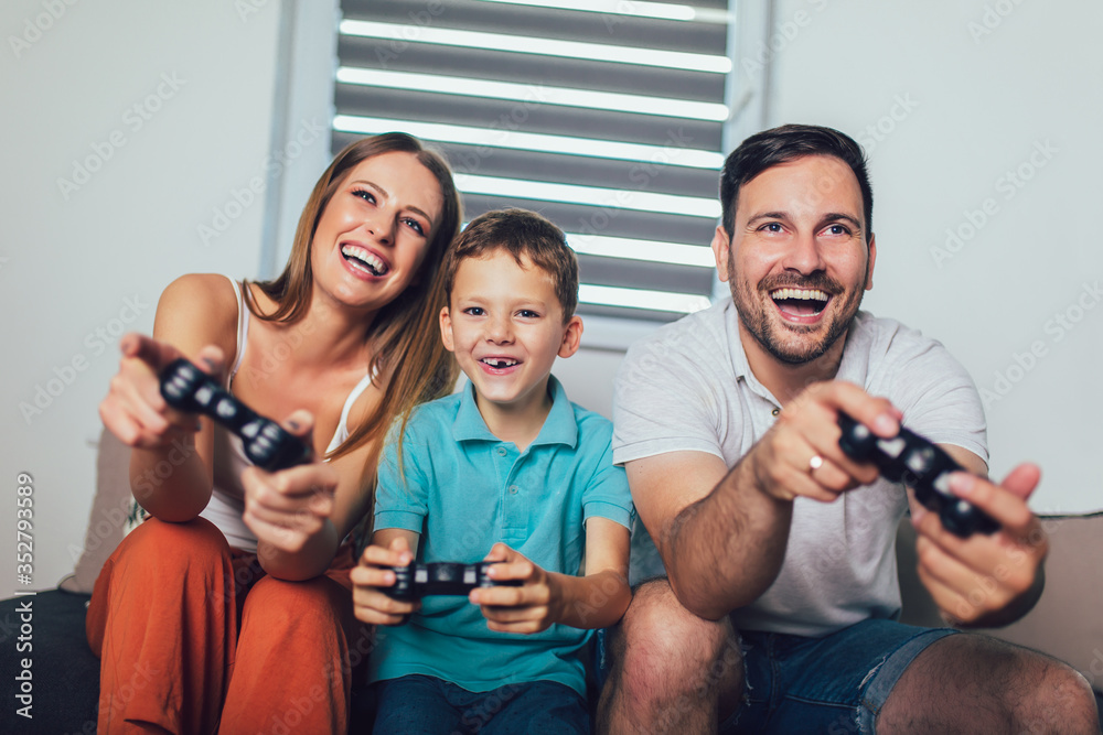 Obraz premium Happy family playing video games at home and having fun together.