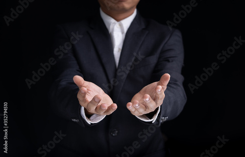 Mid section of a businessman gesturing on black background