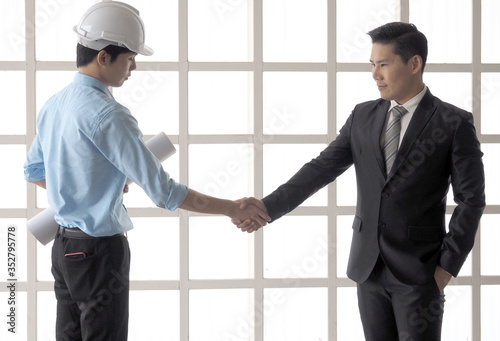 Businessman shake hand with engineer male or foreman or architects asian people.Symbol of success deal, happy partnership, greeting shake