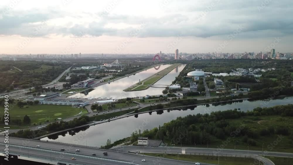 4K quality aerial video scenic view of Grebnoi rowing channel, green park, distant city and hills in Krylatskoye area on cloudy afternoon near Moscow River in Moscow, Russia 4K quality aerial video scenic view of Grebnoi rowing channel, green park, distant city and hills in Krylatskoye area on cloudy afternoon near Moscow River in Moscow, Russia