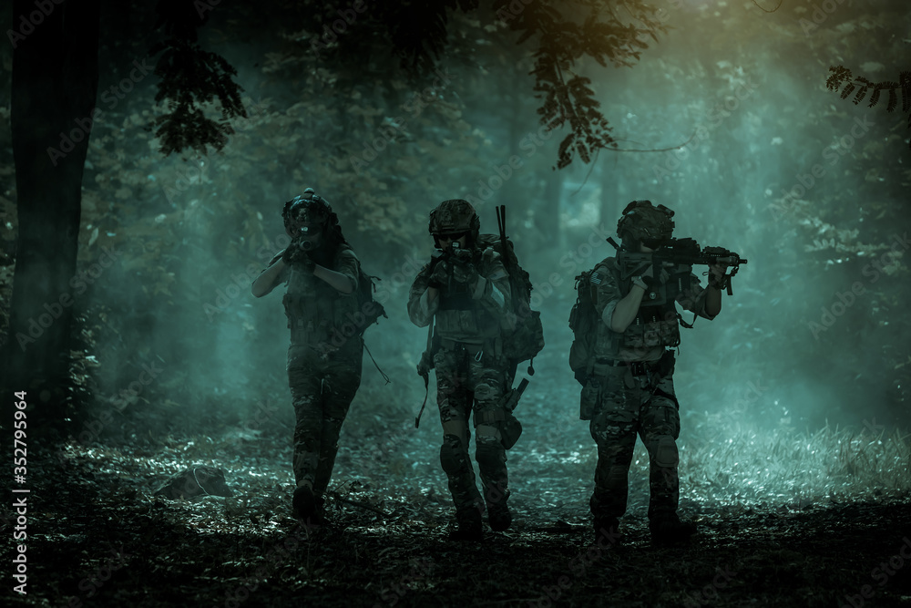 The action soldiers walking hold weapons with smoke light at night time background. The action soldiers walking hold weapons with smoke light at night time background.