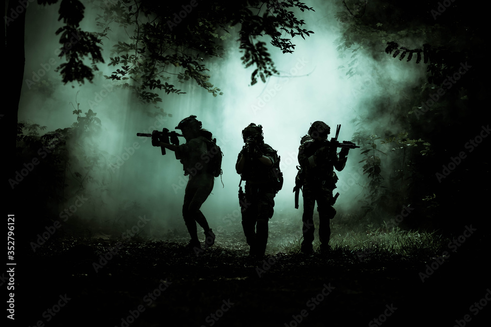 The action soldiers walking hold weapons with smoke light at night time background. The action soldiers walking hold weapons with smoke light at night time background.