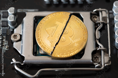 Cryptocurrency bitcoin with cutting traces in the middle on computer CPU mainboard. bitcoin halving concept