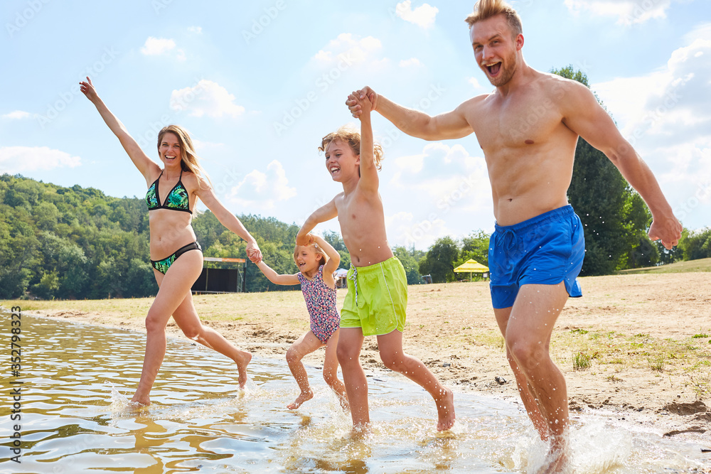 Fröhliche Familie beim Baden und Spielen im See Fröhliche Familie beim Baden und Spielen im See
