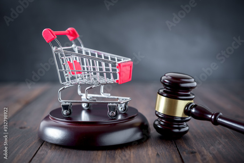 shopping cart and auction hammer on  black  background photo