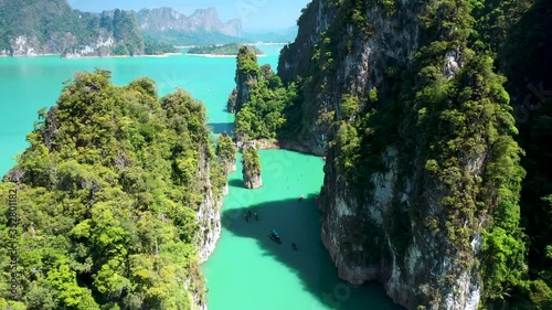 Aerial drone view of beautiful limestone cliffs in a huge tropical lake surrounded by lush, dense rainforest