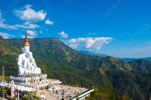 Five white Buddha statue with green mountain and blue sky background