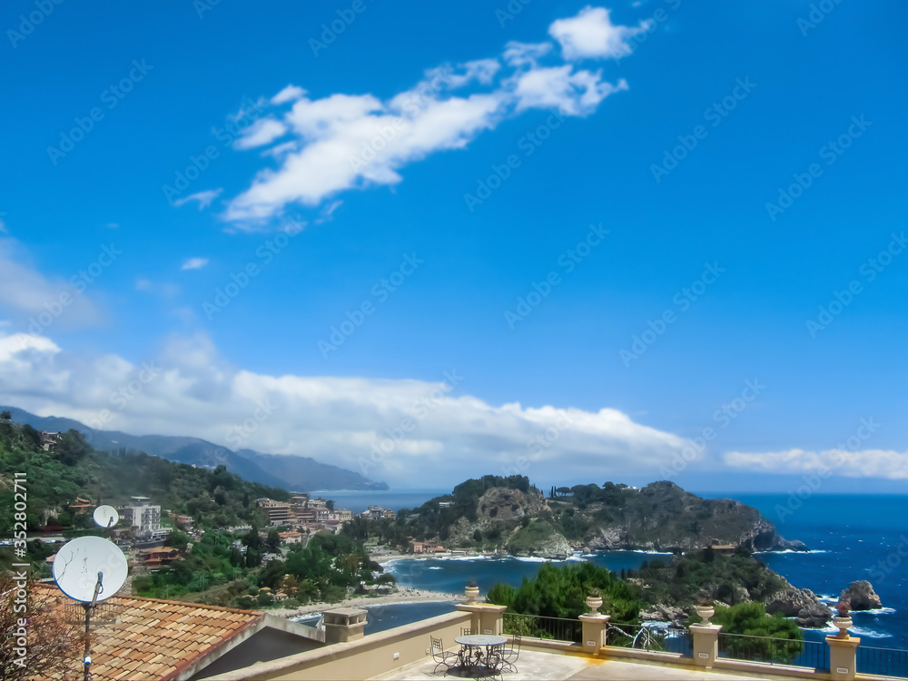 Seascape with blue sea, mountains and houses.
