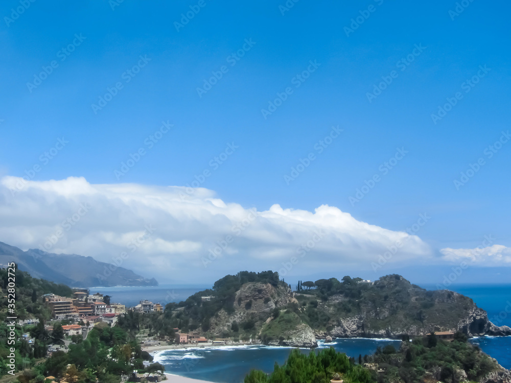 Seascape with blue sea, mountains and houses.