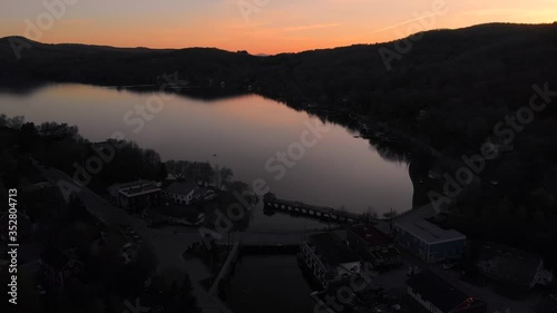 Stunning Landscape Of Lake Massawippi At Dusk. North Hatley Village By The Mountains At Sunset Time In Quebec, Canada. - aerial drone (backward) photo