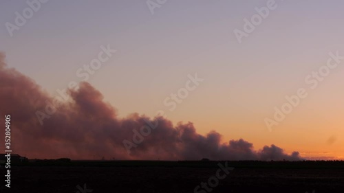 Land, bush fire in the distance Australian outback at dawn, smoke rising across blue sky photo