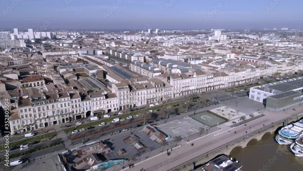 Quai des Chartrons with river cruises on the Garonne river aside Skate Park Colbert in Bordeaux France, Aerial flyover shot