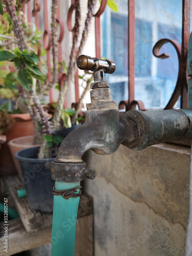 The Old Water tap has a hose was used for many years with blurred background