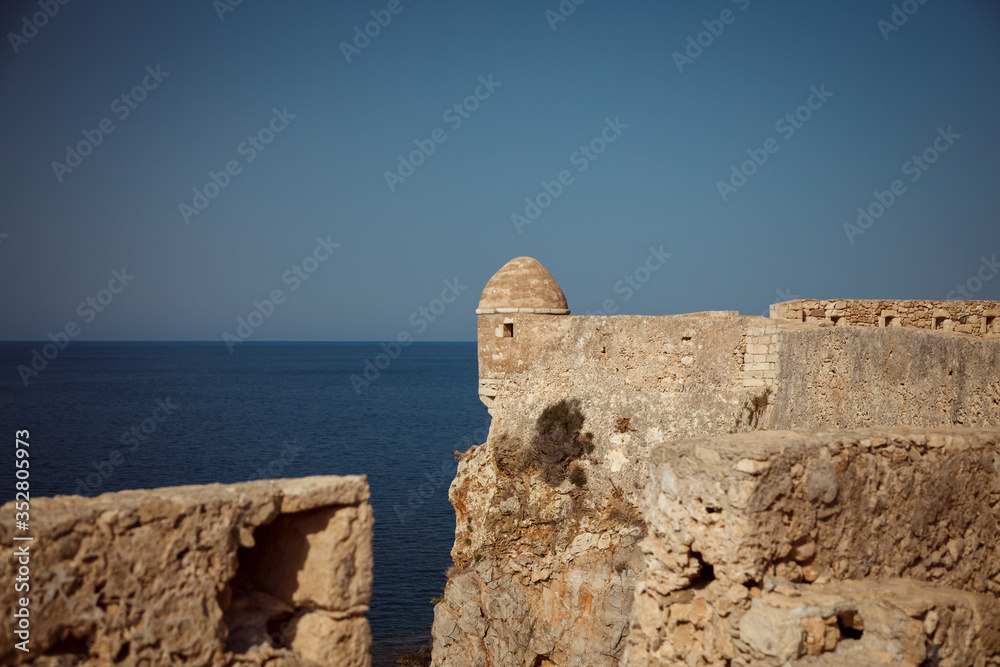 Large stone ancient fortress standing on the edge of a cliff in Greece.