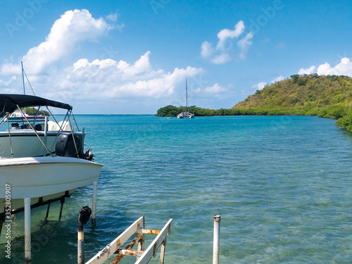 Turquoise waters of the Caribbean Sea with pleasure boats and lush vegetation. Idyllic tropical landscape. © Su Nitram