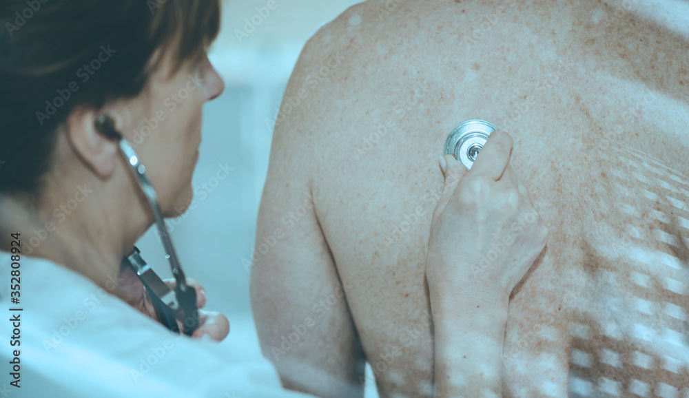 Female doctor using stethoscope to exam patient; light effect Female doctor using stethoscope to exam patient; light effect