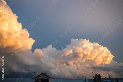 Cloudscape photography, fluffy clouds coloured with sunset light in London photo