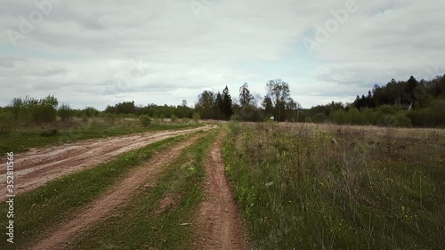Cinematic movement along a country dirt road on a cloudy day in may. Color graded. 
New Moscow, Russia.