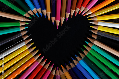 Color pencils heart isolated on black background close up with Clipping path.Beautiful color pencils.Color pencils for drawing Rainbow color pencil and used as a background.copy space for your image photo